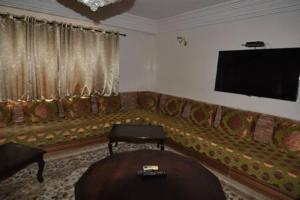 salon z kanapą i telewizorem z płaskim ekranem w obiekcie Babylon Appartments w Marakeszu