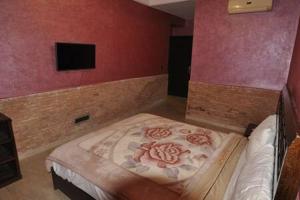 um quarto com uma cama num quarto com paredes cor-de-rosa em Babylon Appartments em Marrakech