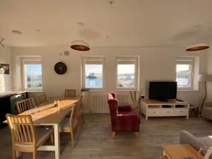 a living room with a table and chairs and a television at 4 South Beach Stornoway in Stornoway