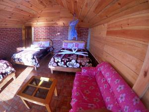 una habitación con 2 camas y un sofá en una cabaña en Cabañas Paraiso tziscao, en Comitán de Domínguez