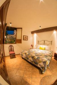 a bedroom with a bed and a chair at Hotel Mesón de los Remedios in Morelia