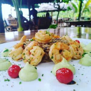 a plate of food with shrimp on a table at Hotel Bambú in Canoa
