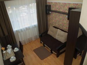a small living room with a chair and a window at Leon Hotel in Lviv
