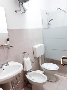 W łazience znajduje się umywalka, toaleta i lustro. w obiekcie Villa RaFà w mieście Avola