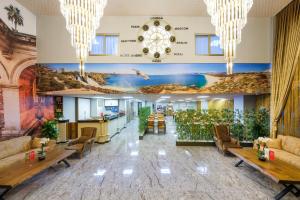 una hall con divani, tavoli e un murale di Grand Gulluk Hotel & Spa a Antalya (Adalia)