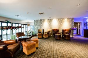a waiting room with leather chairs and tables at Barony Castle Hotel in Peebles