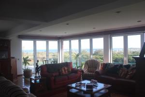 a living room with couches and a large window at Moradia da Graça in Praia da Vitória