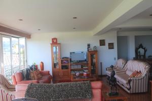 uma sala de estar com dois sofás e uma televisão em Moradia da Graça em Praia da Vitória