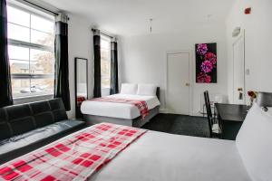 a hotel room with two beds and a couch at OYO Gin House Hotel in Greenock