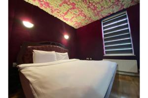 1 dormitorio con cama blanca y ventana en SK Baylis House Hotel, en Slough