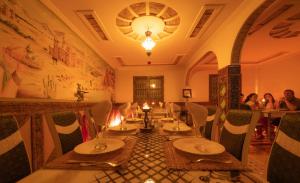 a restaurant with tables and chairs in a room at Riad Rihana Dades in Boumalne