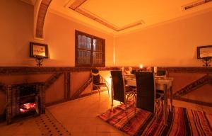 a dining room with a table and a fireplace at Riad Rihana Dades in Boumalne