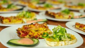a table topped with plates of pizza and salad at Riad Rihana Dades in Boumalne