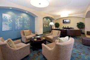 a waiting room with chairs and a table and a desk at Candlewood Suites Greeley, an IHG Hotel in Greeley