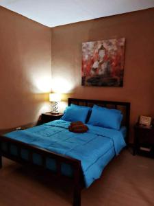 a bedroom with a large bed with blue sheets at Carlo'S Place in Dumaguete
