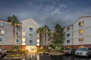 a large white building with cars parked in a parking lot at Candlewood Suites Lake Mary, an IHG Hotel in Lake Mary