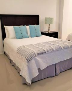 ein Schlafzimmer mit einem großen Bett mit blauen Kissen in der Unterkunft KASA The Lofts of Old San Juan 202 HUGE 2 Bed 2 bath for 6 Interior Terrace in San Juan