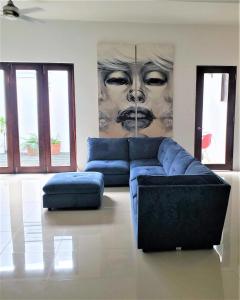 KASA The Lofts of Old San Juan 202 HUGE 2 Bed 2 bath for 6 Interior Terrace في سان خوان: غرفة معيشة بها أريكة زرقاء و لوحة