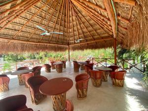 een groep tafels en stoelen onder een rieten paraplu bij MIO Cancún Hotel Boutique in Cancun