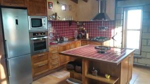 uma cozinha com electrodomésticos de aço inoxidável e azulejos vermelhos em Casa Zenaida em El Río
