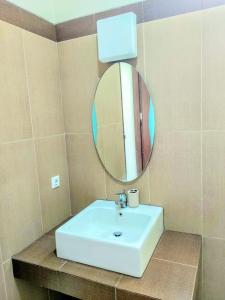 een badkamer met een witte wastafel en een spiegel bij Villa Ubud Syariah in Bandung