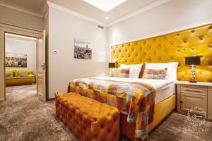 a bedroom with a large bed and a yellow headboard at Golden Key Boutique Hotel in Karlovy Vary