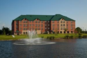 a building with a fountain in the middle of a pond at Staybridge Suites West Des Moines, an IHG Hotel in Clive
