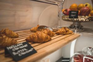 a table with croissants and apples on a shelf at Golden Key Boutique Hotel in Karlovy Vary