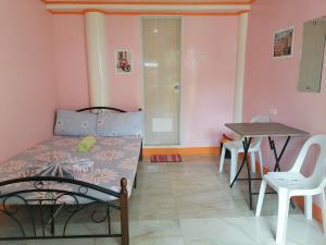 ein Wohnzimmer mit einem Bett und einem Tisch in der Unterkunft J&J Tourist Inn in Panglao