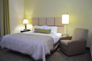 Un pat sau paturi într-o cameră la Candlewood Suites Greenville, an IHG Hotel