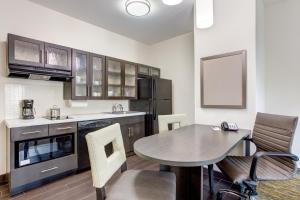 a kitchen with a table and chairs in a kitchen at Candlewood Suites Cut Off - Galliano by IHG in Galliano