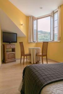 a bedroom with a table and chairs and a television at Hotel Rural Casa Paulino in Taramundi