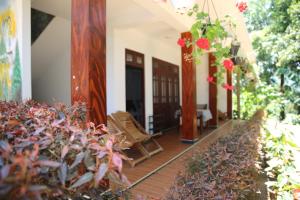 een veranda van een huis met planten en bloemen bij The Dream Resort in Ella