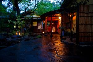 a house with lights on the side of it at night at Kappo Ryokan Kannawa Bettei in Beppu