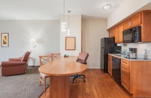 cocina con mesa de madera y cocina con comedor en Candlewood Suites Houston I-10 East, an IHG Hotel, en Houston