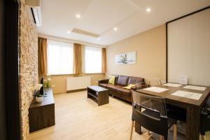 a living room with a table and a couch at Apartments Brigitte in Bratislava