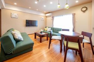 a living room with a couch and a table at Hotel Haabesu Okinawa in Urazoe