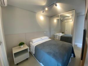 um quarto com uma cama grande e um espelho em SUA CASA NA VILA MADALENA em São Paulo