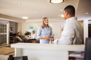 Kobieta stojąca w biurze rozmawiająca z mężczyzną w obiekcie Candlewood Suites North Little Rock, an IHG Hotel w mieście North Little Rock
