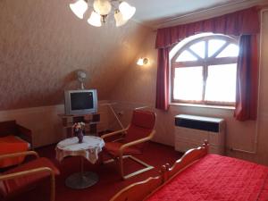 1 dormitorio con cama, mesa y TV en Zsoli Vendégház, en Alsópáhok