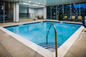 a large swimming pool with blue water in a hotel at Staybridge Suites Des Moines Downtown by IHG in Des Moines