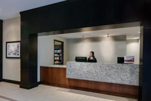 a woman sitting at a counter in a lobby at Staybridge Suites Des Moines Downtown by IHG in Des Moines +28 photos
