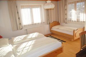 a bedroom with two beds and two windows at Pension Marienhof in Hermagor
