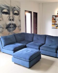 a blue couch in a living room with a painting at KASA The Lofts of Old San Juan 202 HUGE 2 Bed 2 bath for 6 Interior Terrace in San Juan