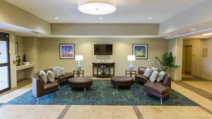 una sala d'attesa con divani e TV a schermo piatto di Candlewood Suites Overland Park W 135th St, an IHG Hotel a Overland Park