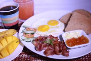 a plate of breakfast food with eggs bacon and bread at Beehive Hostel Kathmandu in Kathmandu