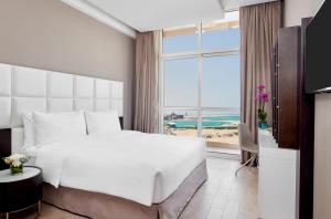 A bed or beds in a room at Staybridge Suites - Doha Lusail by IHG