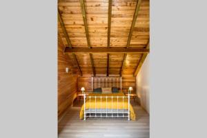 Habitación con cama amarilla en el techo de madera. en Barbadine en La Plaine des Cafres