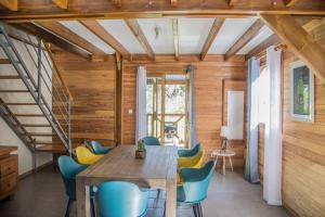 a dining room with a wooden table and blue chairs at Barbadine974 in La Plaine des Cafres