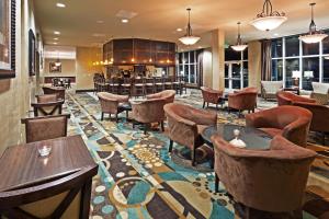 a lobby with tables and chairs and a bar at Holiday Inn Hotel & Suites Beaufort at Highway 21, an IHG Hotel in Beaufort